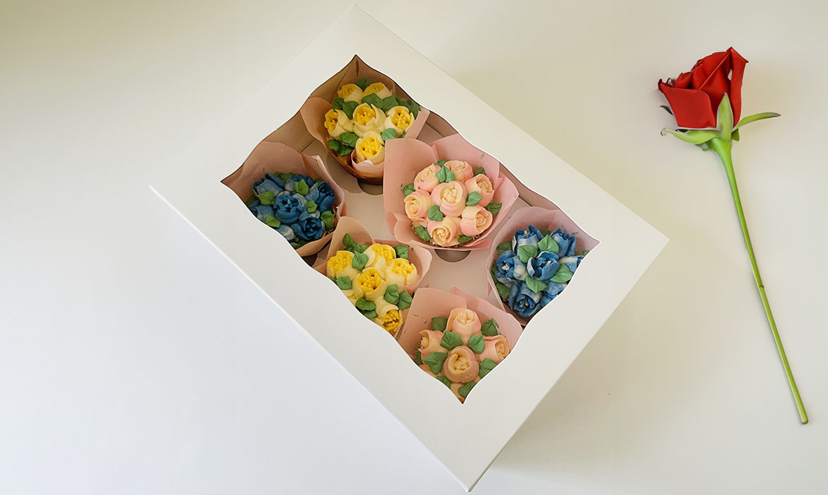 box of six cupcakes for mother's day, each cupcake has custom designed mini frosting rose bouquets